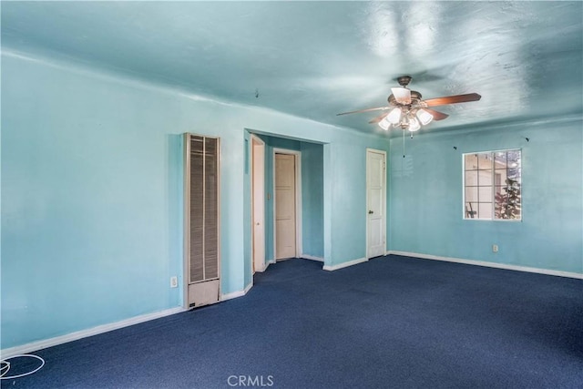 unfurnished room featuring ceiling fan and dark carpet