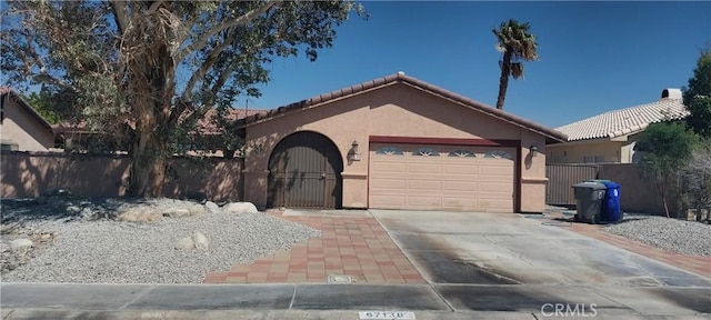 67130 Garbino Rd, Cathedral City, CA 92234 - ranch-style home featuring a garage, stucco siding, a tiled roof, and fence