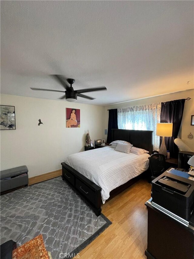 bedroom featuring a textured ceiling, ceiling fan, and hardwood / wood-style flooring