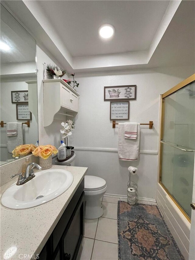 full bathroom with tile patterned floors, shower / bath combination with glass door, vanity, and toilet