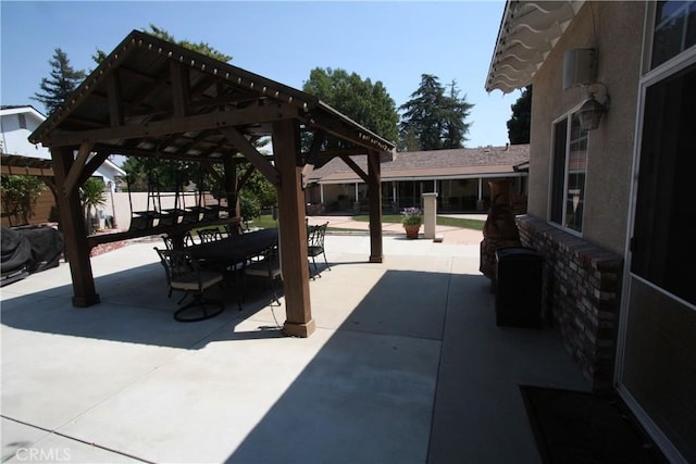 view of patio featuring fence, outdoor dining area, and a gazebo