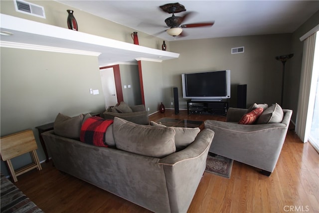 living room with light wood-type flooring, lofted ceiling, ceiling fan, and crown molding