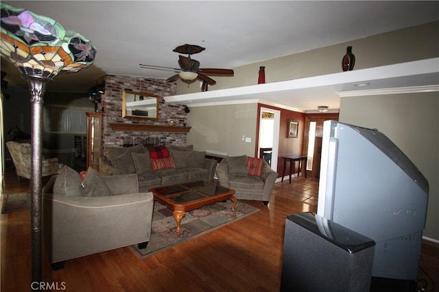 living room with ornamental molding, a brick fireplace, ceiling fan, and hardwood / wood-style flooring