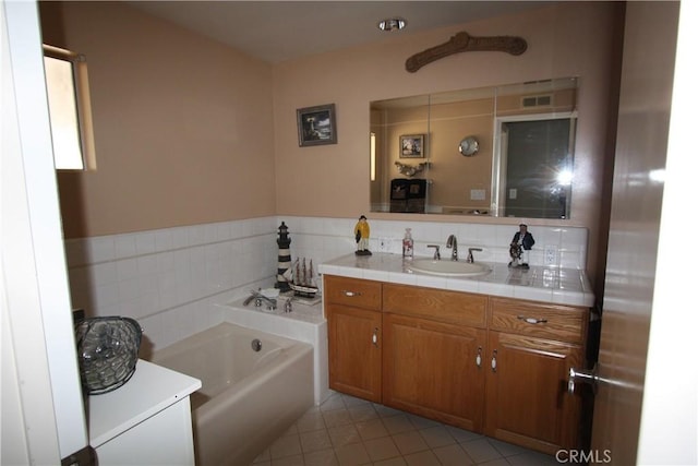 bathroom with a garden tub, tile patterned flooring, visible vents, and vanity