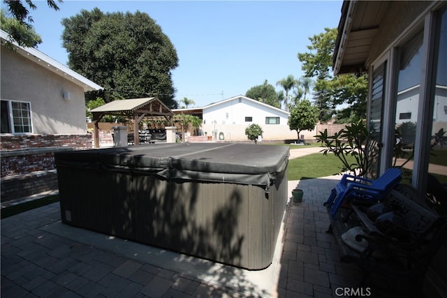 view of patio with a hot tub and a gazebo