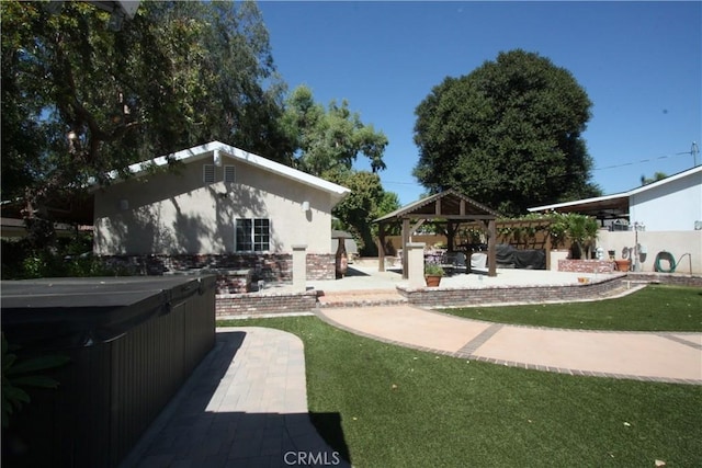 view of yard featuring a gazebo, a patio area, and a hot tub