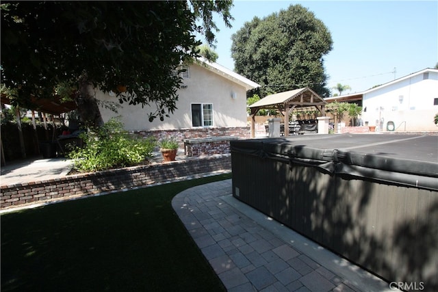 view of patio featuring a gazebo and a hot tub