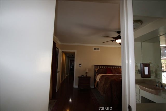 bedroom with visible vents, a ceiling fan, ornamental molding, wood finished floors, and a sink