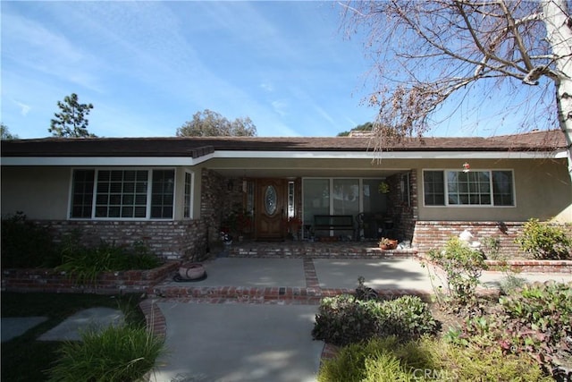 view of front facade with brick siding and stucco siding