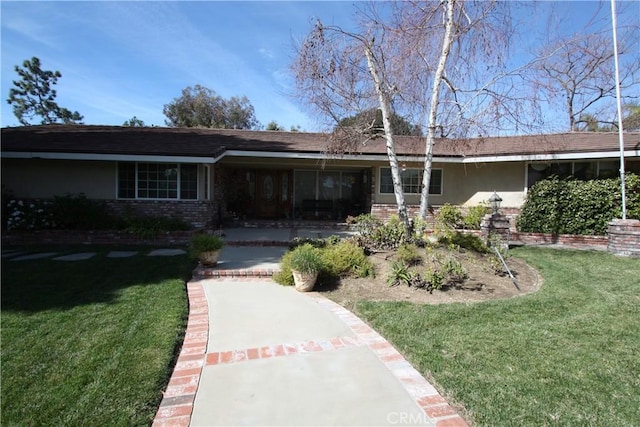 view of front facade featuring a front yard and brick siding