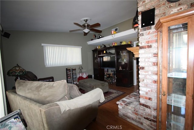 living area with dark wood-type flooring, a ceiling fan, and a healthy amount of sunlight