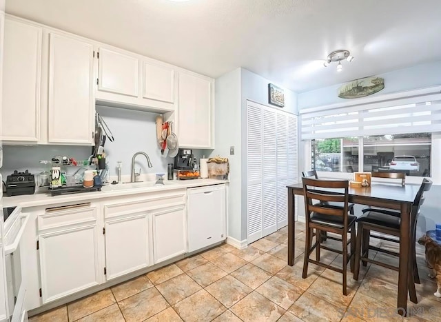 kitchen featuring white cabinetry and white dishwasher