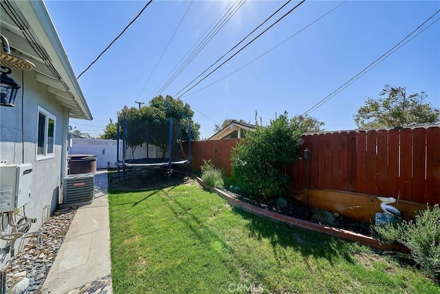 view of yard featuring ac unit, central AC unit, and a trampoline