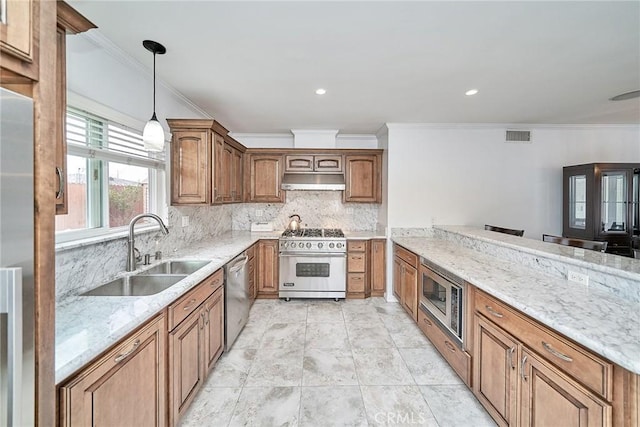 kitchen featuring sink, decorative backsplash, light stone countertops, appliances with stainless steel finishes, and decorative light fixtures