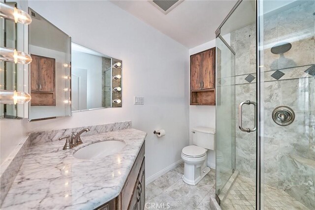 bathroom featuring vanity, an enclosed shower, and toilet