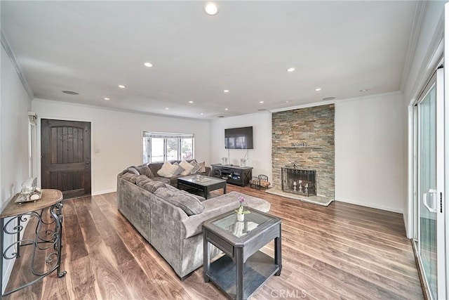 living room with a fireplace, wood-type flooring, and ornamental molding