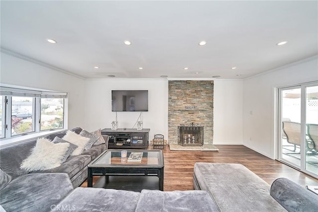 living room featuring hardwood / wood-style flooring, crown molding, and a fireplace