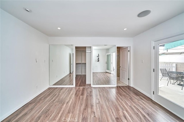 unfurnished bedroom featuring hardwood / wood-style floors, access to outside, and a closet