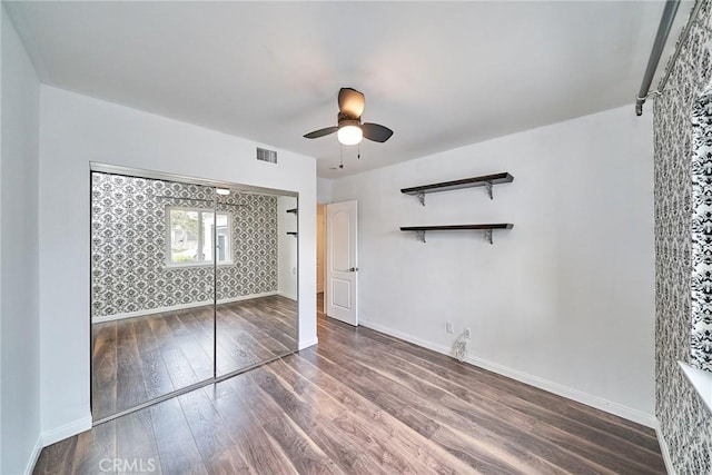 unfurnished bedroom featuring ceiling fan, a closet, and hardwood / wood-style flooring