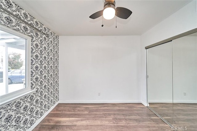 empty room with ceiling fan and wood-type flooring