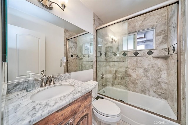 full bathroom with combined bath / shower with glass door, vanity, and toilet