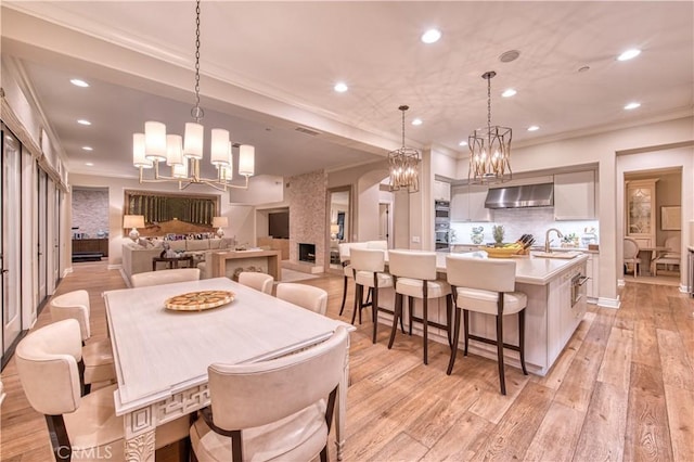 dining space featuring recessed lighting, light wood-style floors, a chandelier, and crown molding