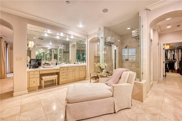 bathroom featuring a spacious closet, baseboards, ornamental molding, a stall shower, and vanity