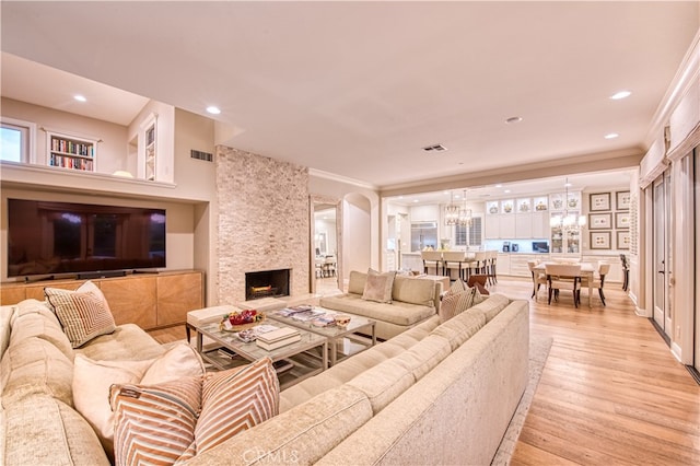 living room featuring light hardwood / wood-style flooring, a fireplace, and crown molding