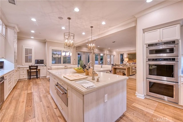 kitchen featuring light wood finished floors, stainless steel double oven, a warming drawer, and ornamental molding