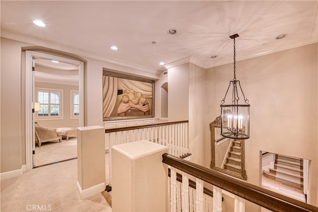 hallway with ornamental molding and light colored carpet