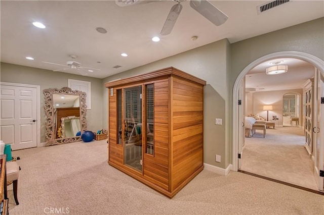 interior space with visible vents, carpet floors, baseboards, recessed lighting, and arched walkways