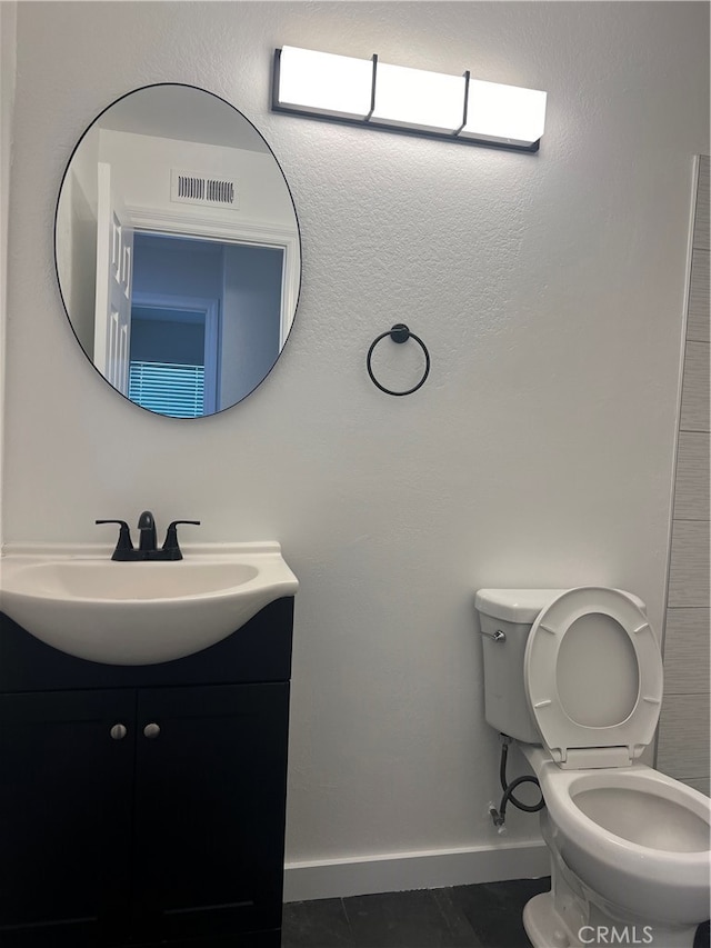 bathroom with tile patterned flooring, vanity, and toilet