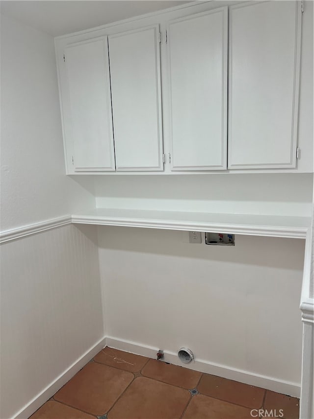 clothes washing area with hookup for a washing machine, cabinets, and dark tile patterned floors