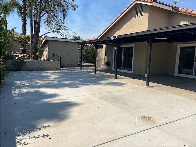 back of house featuring a patio and a storage shed