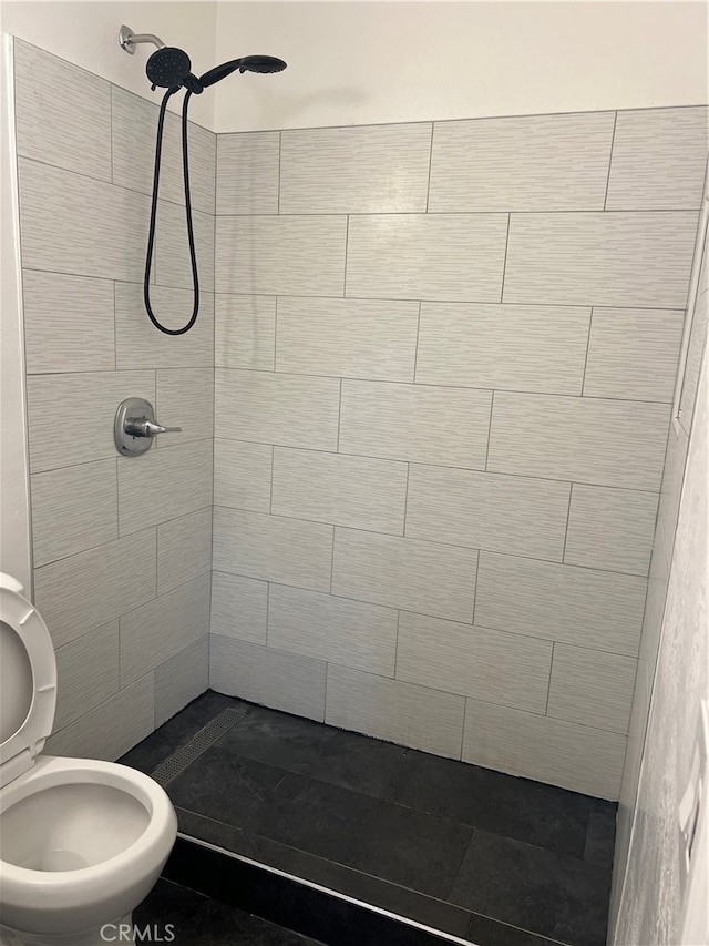 bathroom featuring toilet and tiled shower