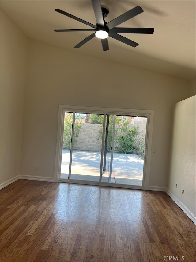 empty room with lofted ceiling, ceiling fan, and dark hardwood / wood-style floors