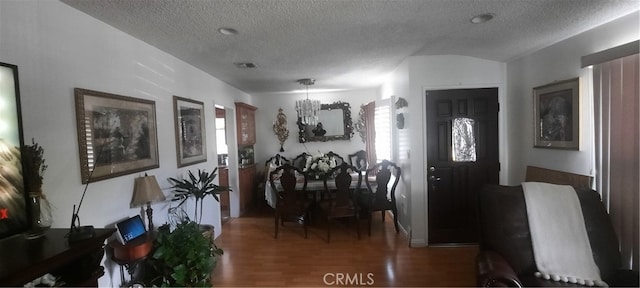 dining room with a textured ceiling, plenty of natural light, and hardwood / wood-style floors