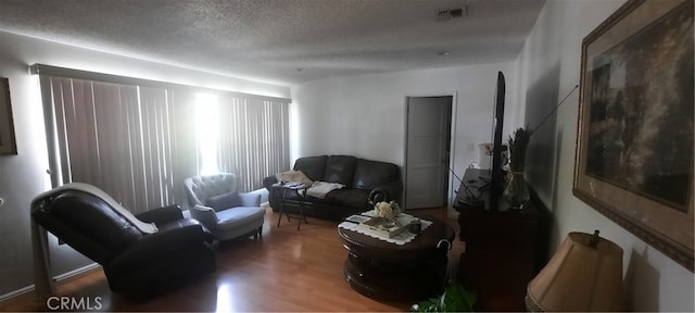 living room featuring a textured ceiling and dark hardwood / wood-style flooring