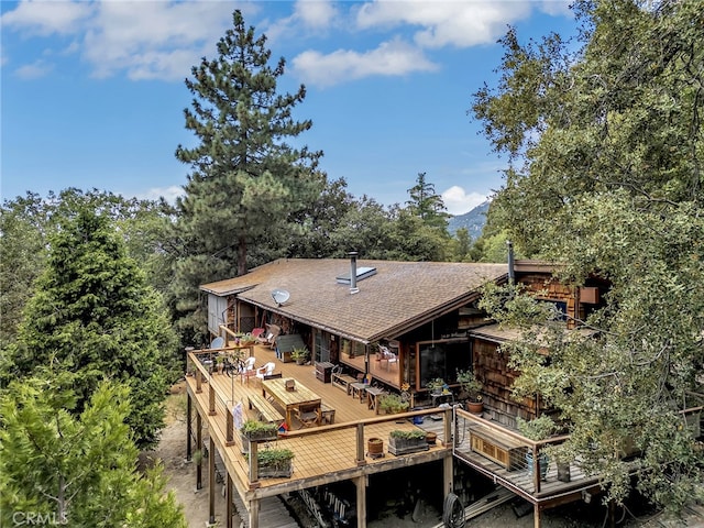 rear view of house featuring a wooden deck