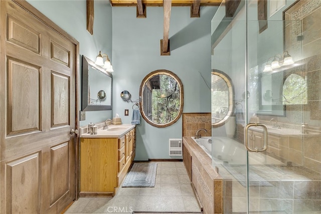 bathroom with tiled tub, vanity, plenty of natural light, and tile patterned floors