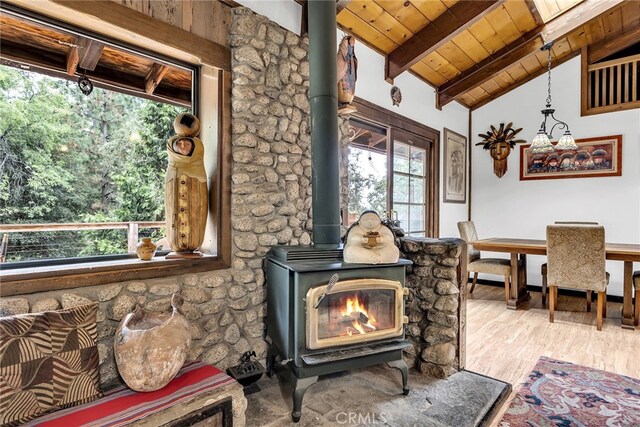 interior details featuring a wood stove, beam ceiling, hardwood / wood-style flooring, and wooden ceiling