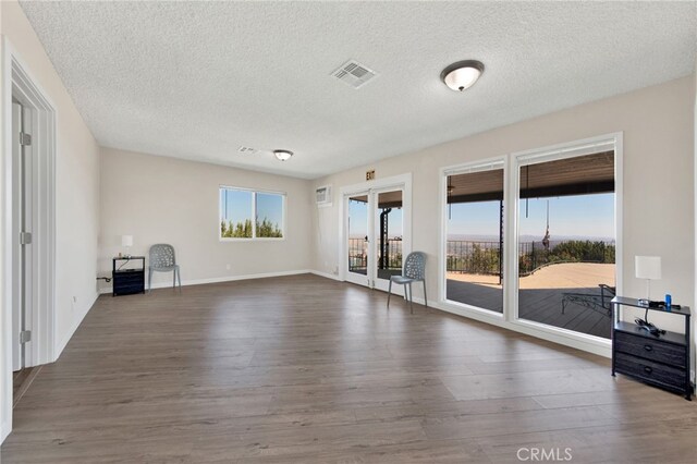 unfurnished living room featuring a textured ceiling and dark hardwood / wood-style flooring