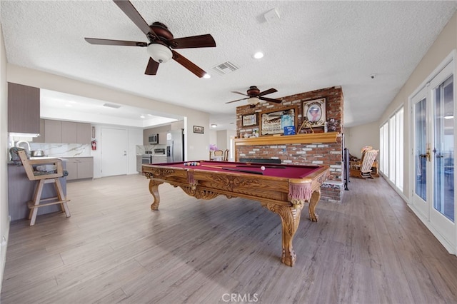 recreation room with ceiling fan, french doors, a textured ceiling, pool table, and light hardwood / wood-style floors