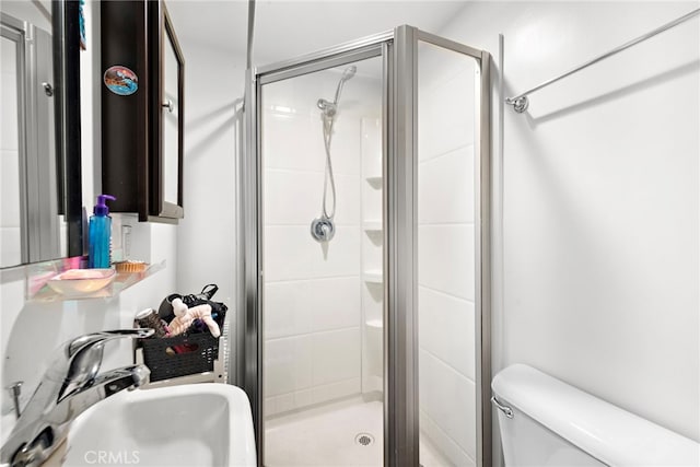 bathroom featuring sink, an enclosed shower, and toilet