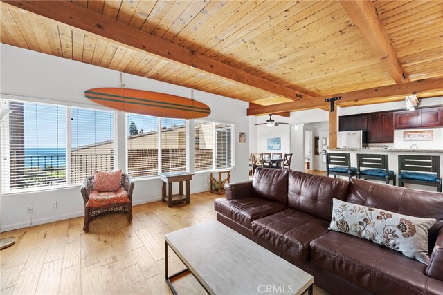 living room with beamed ceiling, light hardwood / wood-style flooring, ceiling fan, and wood ceiling