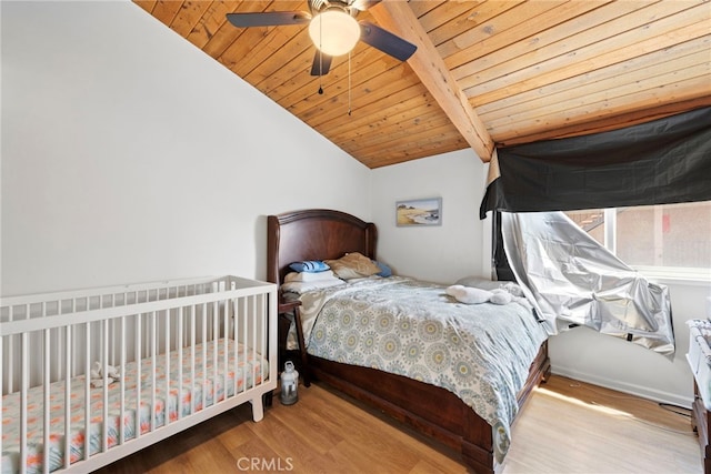 bedroom featuring vaulted ceiling with beams, ceiling fan, light hardwood / wood-style flooring, and wood ceiling