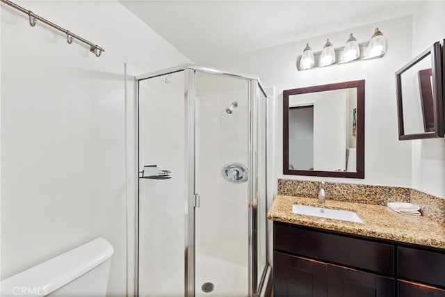 bathroom featuring toilet, vanity, and walk in shower