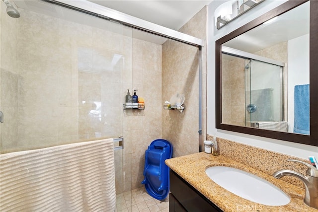 bathroom with tile patterned flooring, vanity, walk in shower, and tile walls