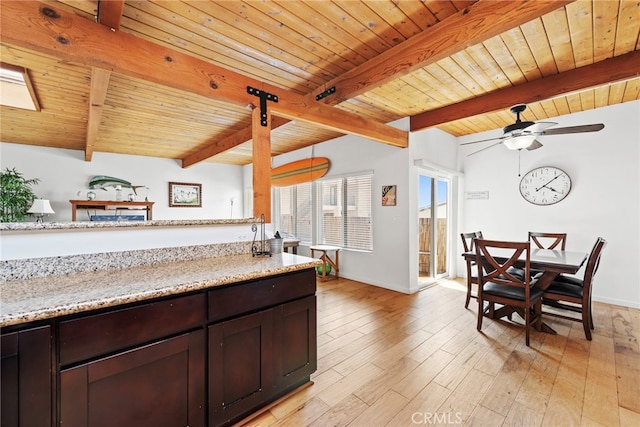 kitchen with light stone countertops, lofted ceiling with beams, wooden ceiling, and light wood-type flooring