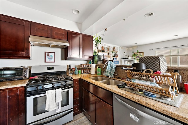 kitchen featuring light stone countertops, sink, stainless steel appliances, and extractor fan